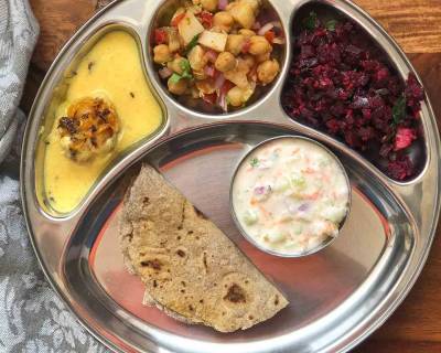 Portion Control Meal Plate: Methi Pakora kadhi, Beetroot Poriyal, Kabuli Chana & Raw Mango Salad, Mixed Millet Phulka & Cucumber & Onion Raita